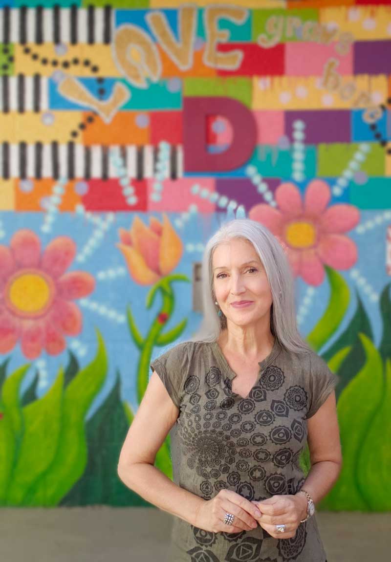 Nancy Good with her public mural, “LOVE Grows Here!”