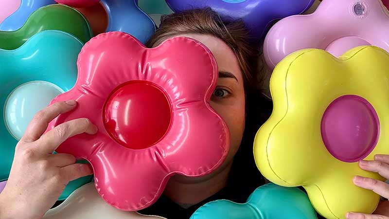Portrait of Artist CJ Hendry with her inflatable flowers at Public Pool - Photo courtesy of CJ Hendry