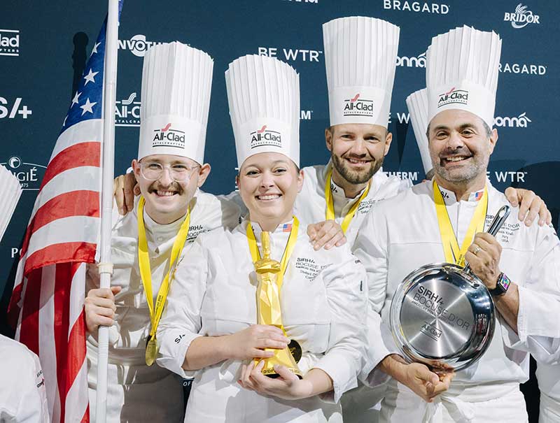 (L-R) Team USA Commis Bradley Waddle, Head Chef Stefani De Palma, Head Coach Sebastian Gibrand and President Chef Devin Knell hold an All-Clad pan. Photo by The French Studio