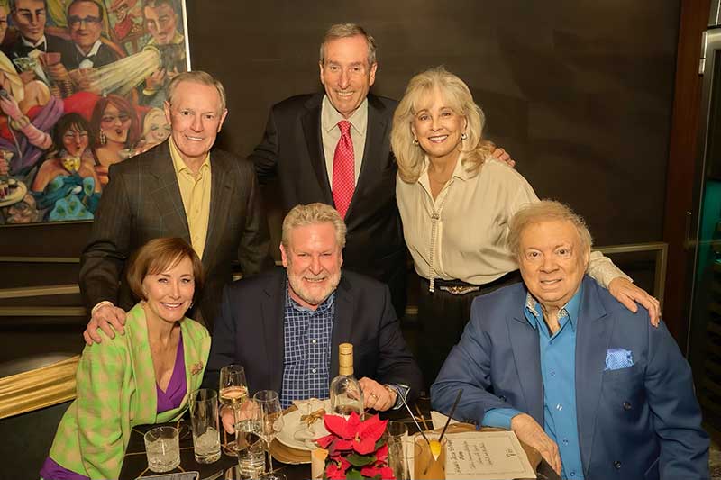 Surrounded by close friends, jazz performer Jeff Hamilton (seated in the center) is joined by Paul Lowden (seated at the right) and Sue Lowden (standing far right)