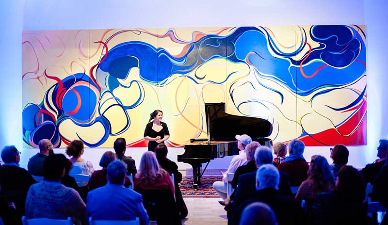 Alexandria Le in front of Rita Deanin Abbey's 30-foot Bridge Mountain painting. Photo by Cactus Creative Collective