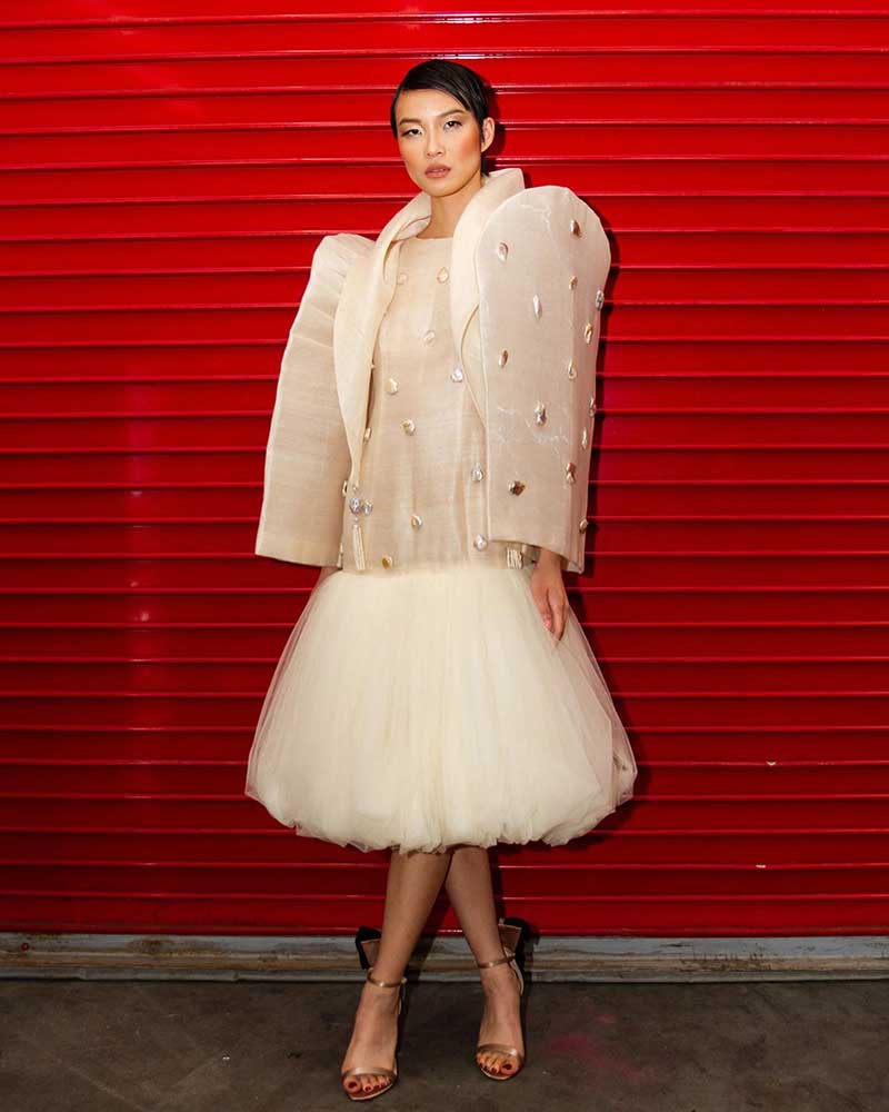 A model shows off one of Puey Quiñones' creations, a modern Filipiniana dress with oversized butterfly sleeves