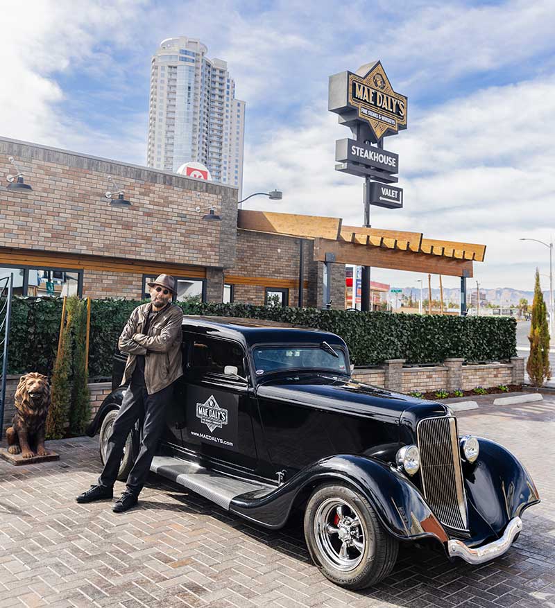 Richard Femenella, owner of Mae Daly's Fine Steaks & Whiskeys, stands in front of his vintage car outside the restaurant