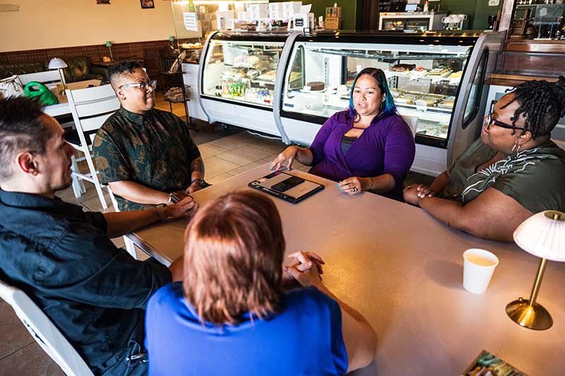 Ashlan Glazier-Anderson meeting with clients at a café